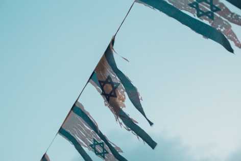  October 19, 2018. Tel Aviv. Israel. Torn Israeli flags fly in the twilight sky.19 octobre 2018. Tel Aviv. Israel. Des drapeaux Isra?liens d?chir?s flottent dans le ciel du cr?puscule.